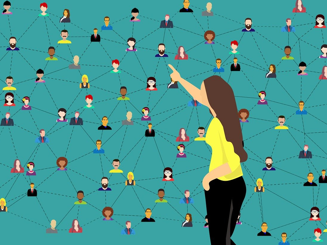 Frau die auf eine Tafel mit vernetzen Personen zeigt